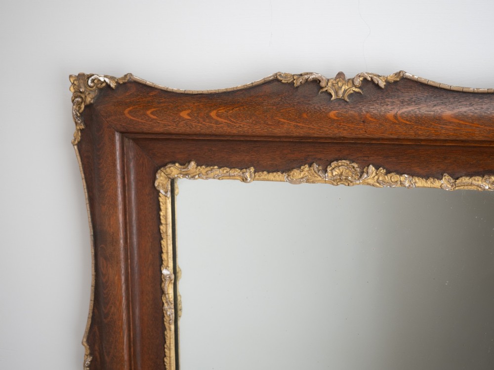 A rectangular dark oak wall mirror featuring a moulded timber frame with gilded gesso accents at the corners, outer edges, and inner sight edge. View V