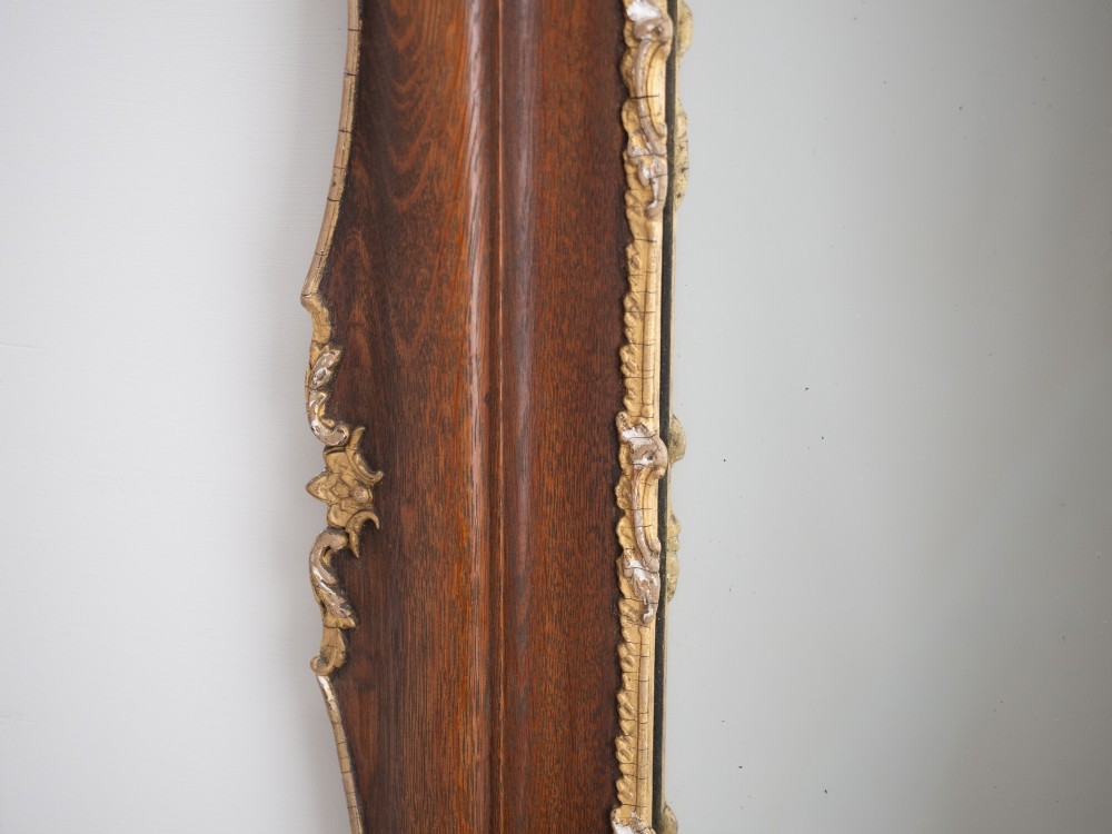 A rectangular dark oak wall mirror featuring a moulded timber frame with gilded gesso accents at the corners, outer edges, and inner sight edge. View VII