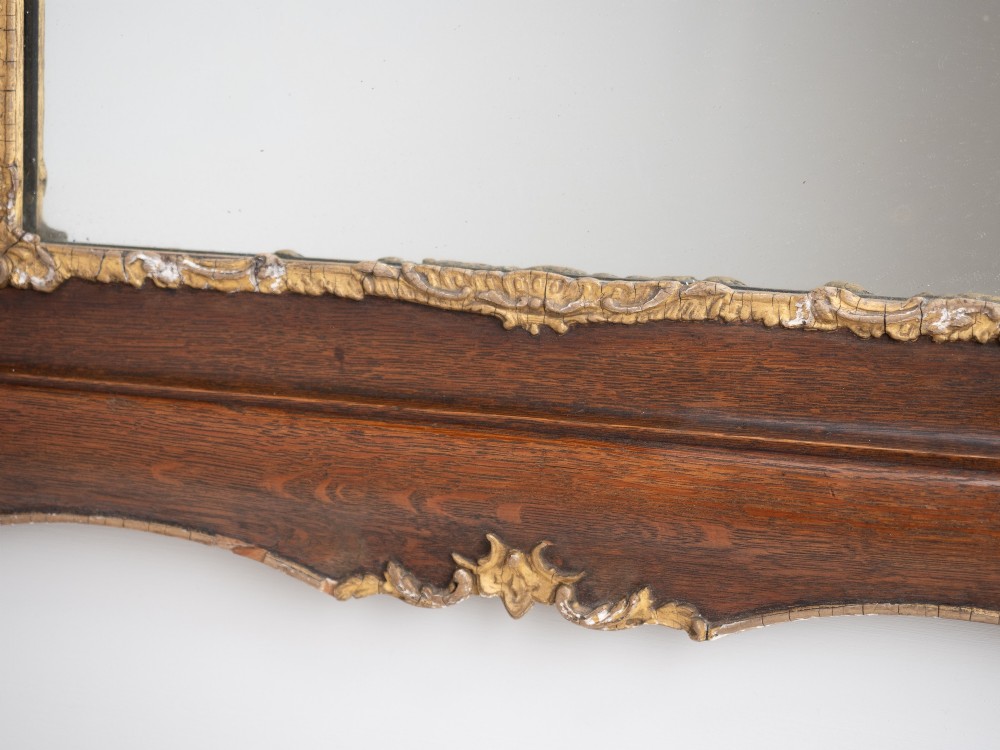 A rectangular dark oak wall mirror featuring a moulded timber frame with gilded gesso accents at the corners, outer edges, and inner sight edge. View X