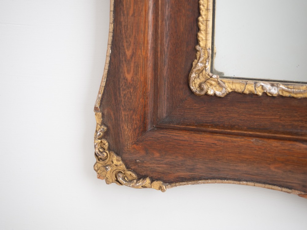 A rectangular dark oak wall mirror featuring a moulded timber frame with gilded gesso accents at the corners, outer edges, and inner sight edge. View XI