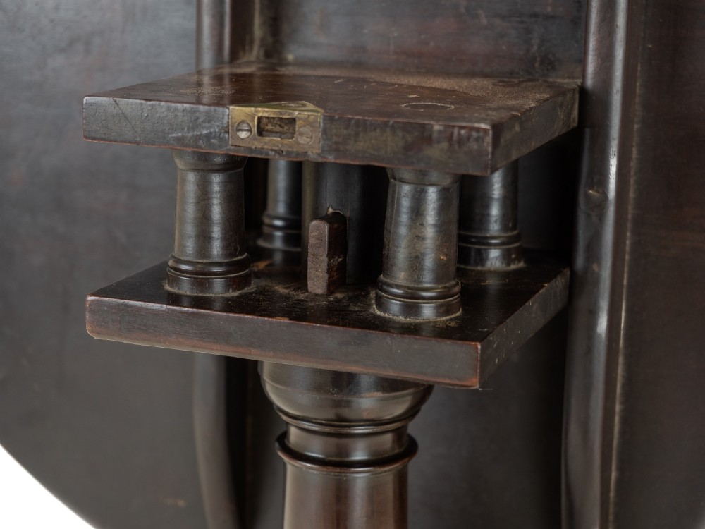 An 18th-century dark mahogany wine table with a round top, spiral-turned central column, and a tripod base with pad feet. View VII