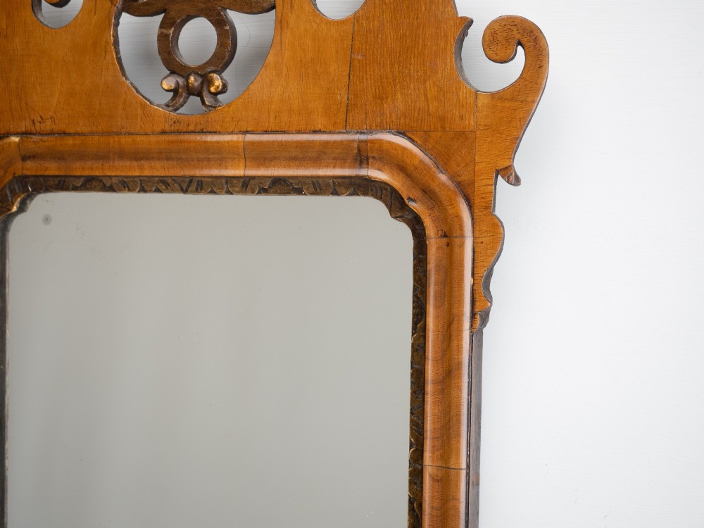 An 18th-century sycamore fretwork wall mirror featuring scrolled cresting with an openwork crest motif, a moulded rectangular frame, and an inner carved gilt slip. View IV