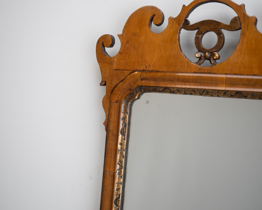 An 18th-century sycamore fretwork wall mirror featuring scrolled cresting with an openwork crest motif, a moulded rectangular frame, and an inner carved gilt slip. View V
