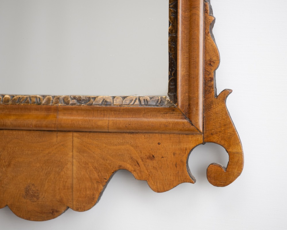 An 18th-century sycamore fretwork wall mirror featuring scrolled cresting with an openwork crest motif, a moulded rectangular frame, and an inner carved gilt slip. View VII