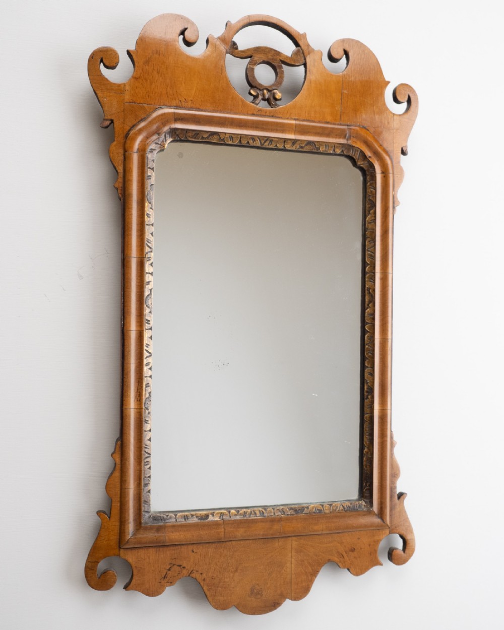 An 18th-century sycamore fretwork wall mirror featuring scrolled cresting with an openwork crest motif, a moulded rectangular frame, and an inner carved gilt slip. View X