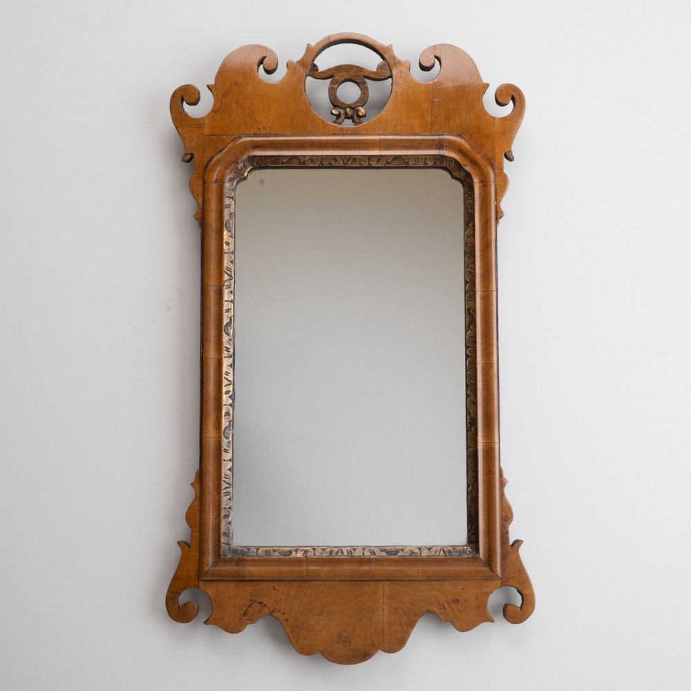 An 18th-century sycamore fretwork wall mirror featuring scrolled cresting with an openwork crest motif, a moulded rectangular frame, and an inner carved gilt slip. View XI