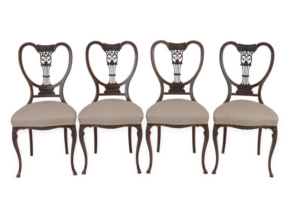 A set of four Sheraton Revival mahogany salon chairs featuring openwork heart-shaped backs with intricate carved splats, neutral upholstered seats, and cabriole front legs. View II