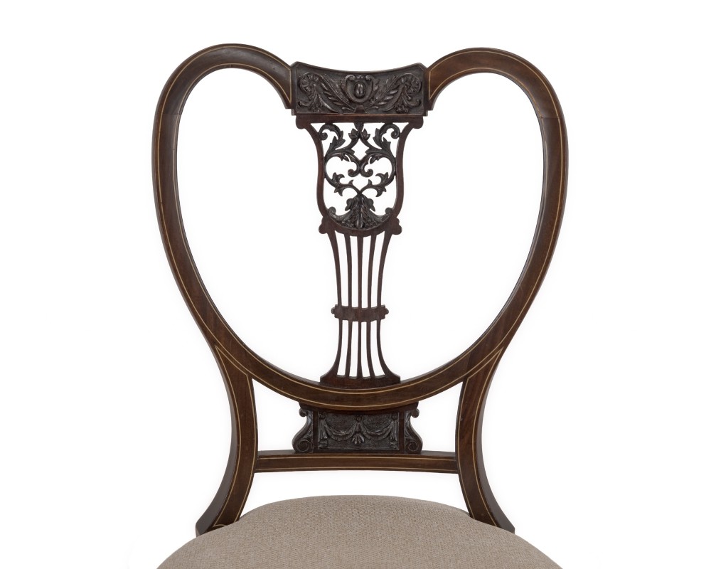 A set of four Sheraton Revival mahogany salon chairs featuring openwork heart-shaped backs with intricate carved splats, neutral upholstered seats, and cabriole front legs. View III
