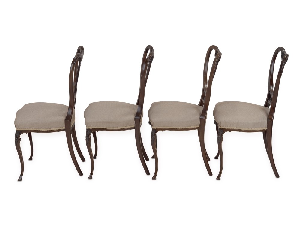 A set of four Sheraton Revival mahogany salon chairs featuring openwork heart-shaped backs with intricate carved splats, neutral upholstered seats, and cabriole front legs. View VI