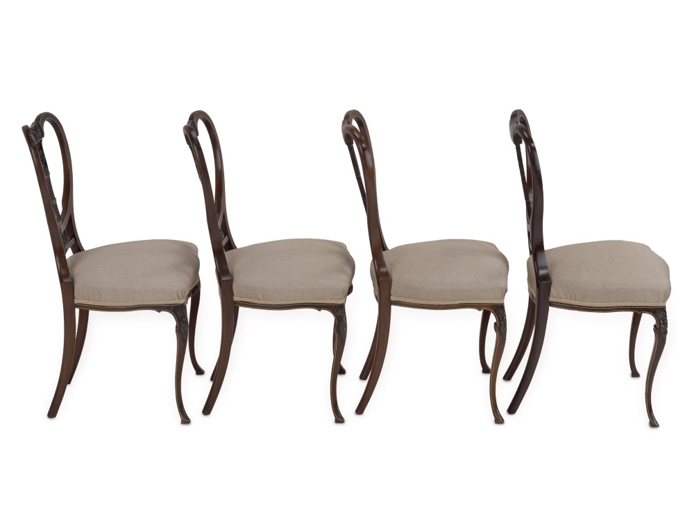 A set of four Sheraton Revival mahogany salon chairs featuring openwork heart-shaped backs with intricate carved splats, neutral upholstered seats, and cabriole front legs. View VII