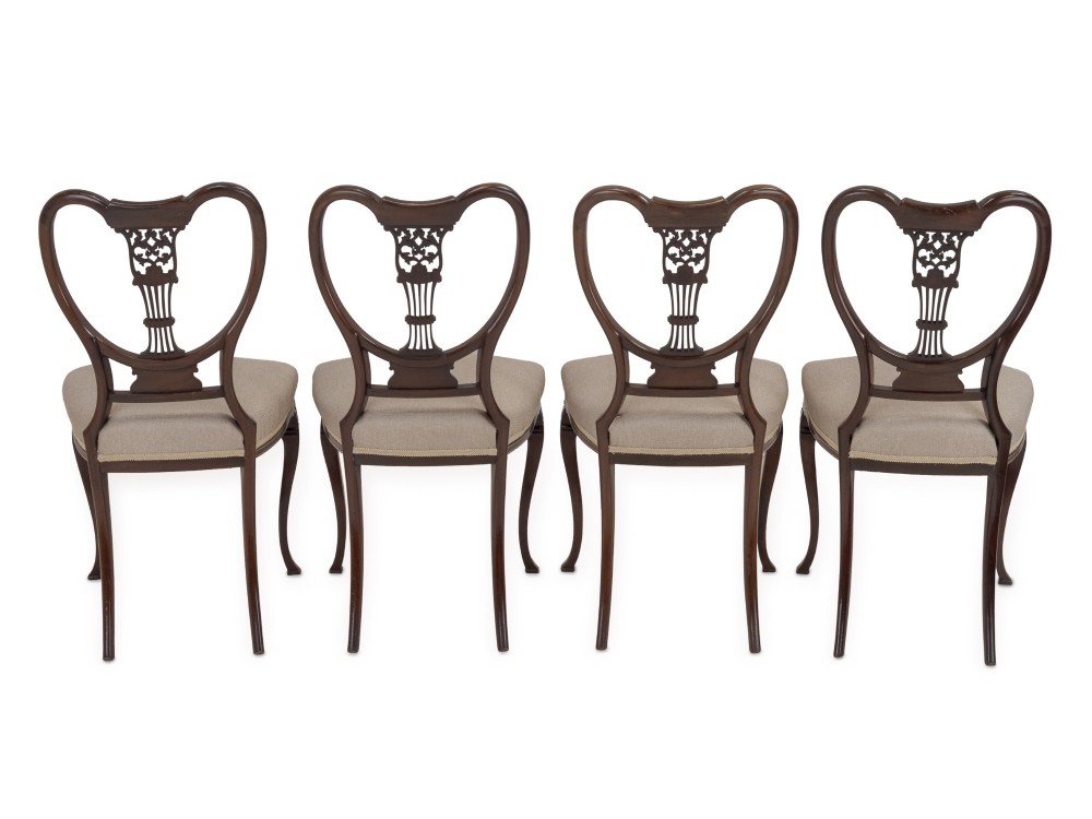 A set of four Sheraton Revival mahogany salon chairs featuring openwork heart-shaped backs with intricate carved splats, neutral upholstered seats, and cabriole front legs. View VIII