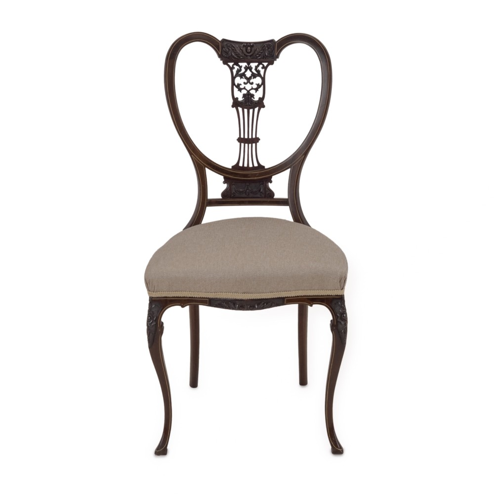 A set of four Sheraton Revival mahogany salon chairs featuring openwork heart-shaped backs with intricate carved splats, neutral upholstered seats, and cabriole front legs. View IX