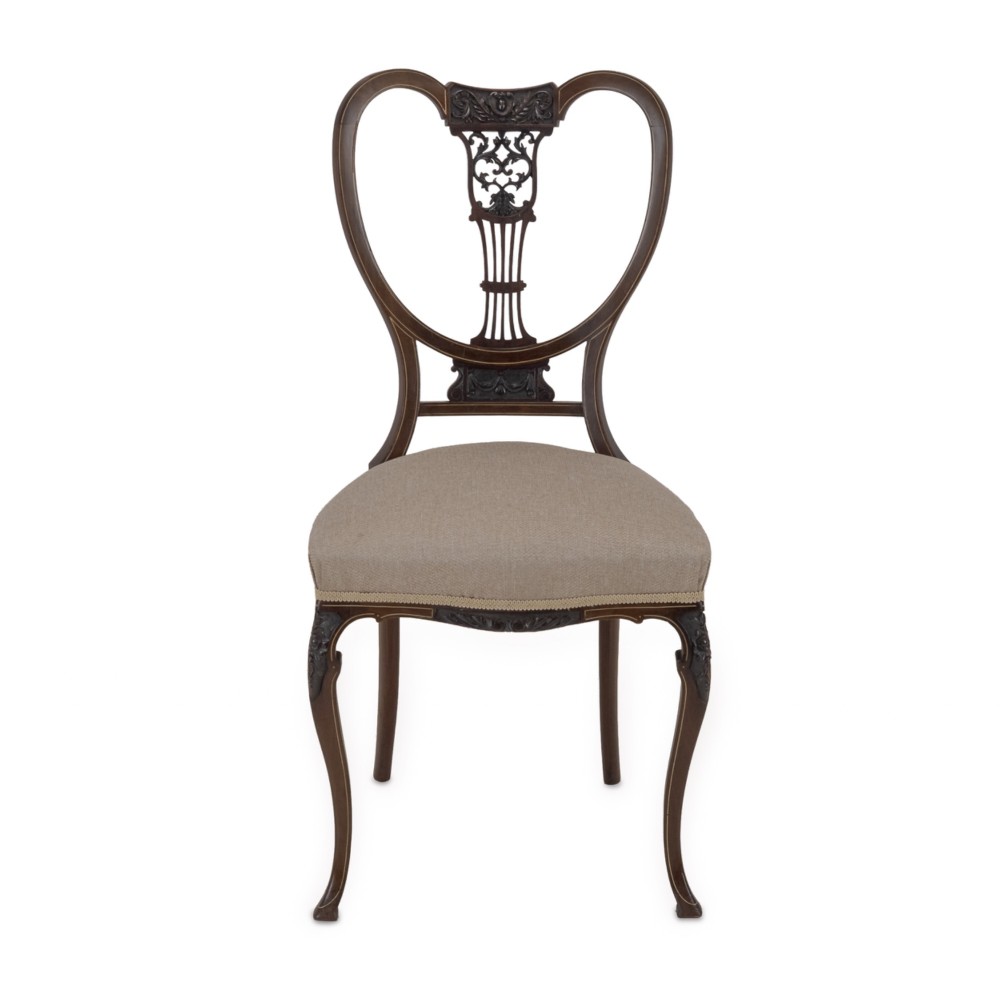 A set of four Sheraton Revival mahogany salon chairs featuring openwork heart-shaped backs with intricate carved splats, neutral upholstered seats, and cabriole front legs. View XI