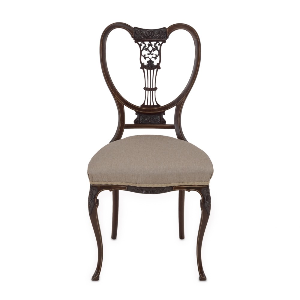A set of four Sheraton Revival mahogany salon chairs featuring openwork heart-shaped backs with intricate carved splats, neutral upholstered seats, and cabriole front legs. View XII