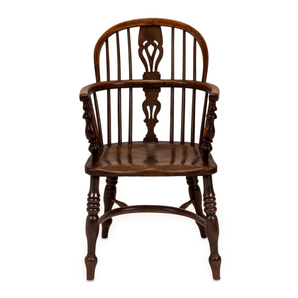 A set of six early 19th-century Windsor armchairs featuring hoop backs, pierced central splats, saddle seats, turned legs, and curved crinoline stretchers. View V