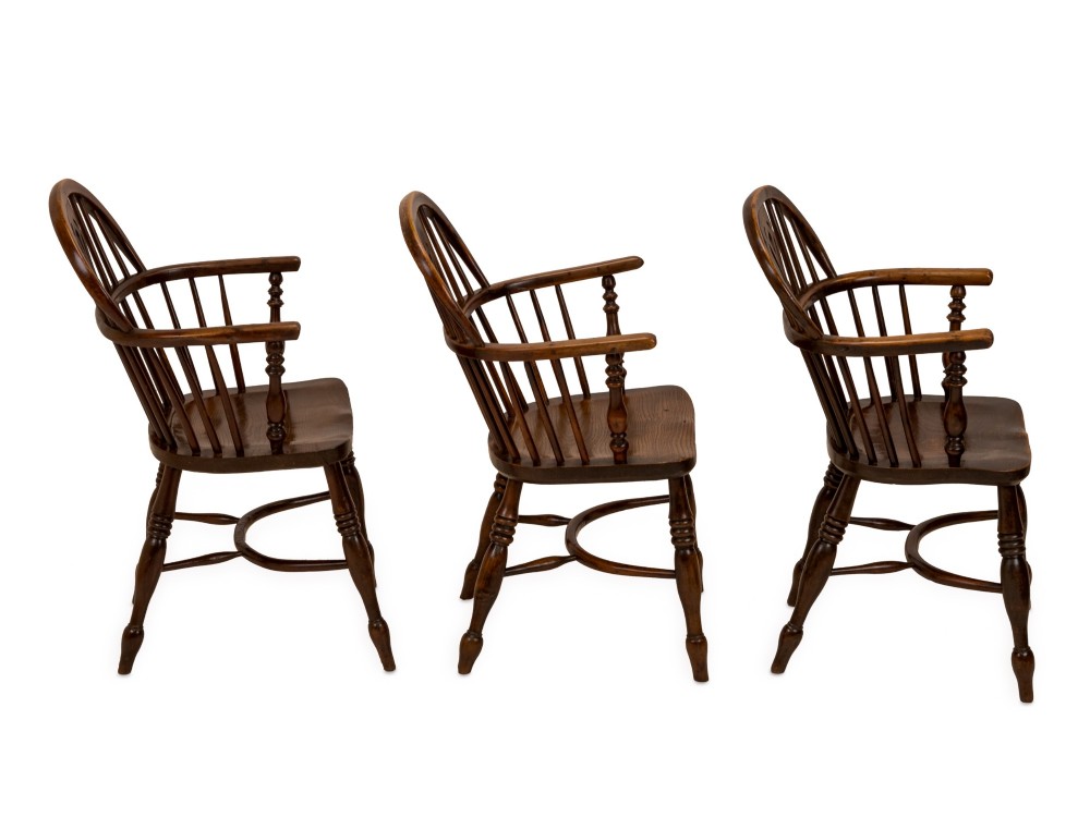 A set of six early 19th-century Windsor armchairs featuring hoop backs, pierced central splats, saddle seats, turned legs, and curved crinoline stretchers. View X