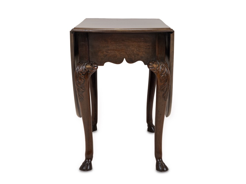 A George II Irish mahogany drop-leaf dining table with an oval top, end drawer, cabriole legs, and carved hoof feet. View III