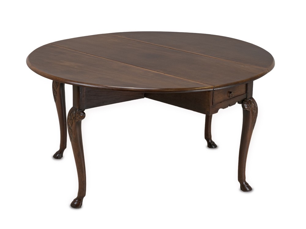 A George II Irish mahogany drop-leaf dining table with an oval top, end drawer, cabriole legs, and carved hoof feet. View IV