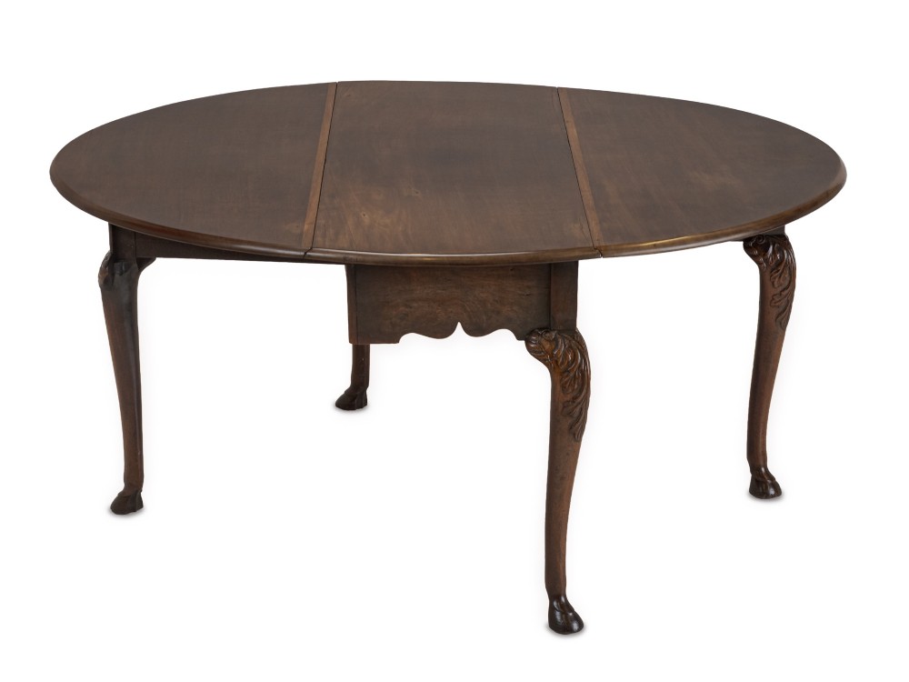 A George II Irish mahogany drop-leaf dining table with an oval top, end drawer, cabriole legs, and carved hoof feet. View V
