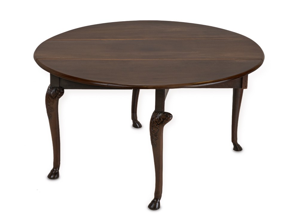 A George II Irish mahogany drop-leaf dining table with an oval top, end drawer, cabriole legs, and carved hoof feet. View VI