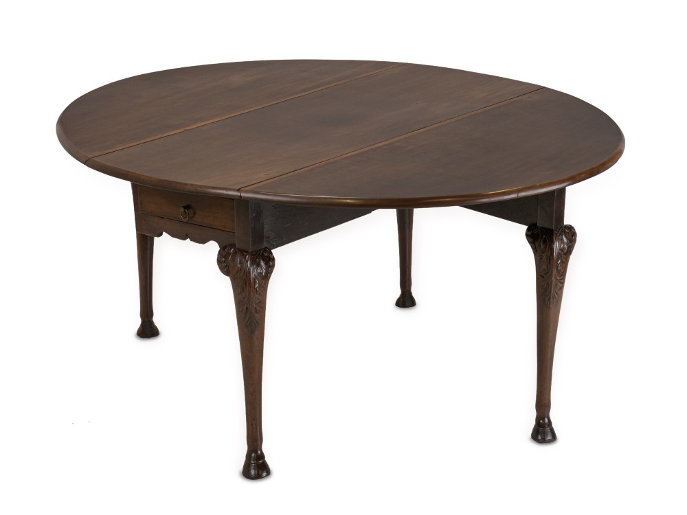 A George II Irish mahogany drop-leaf dining table with an oval top, end drawer, cabriole legs, and carved hoof feet. View VII