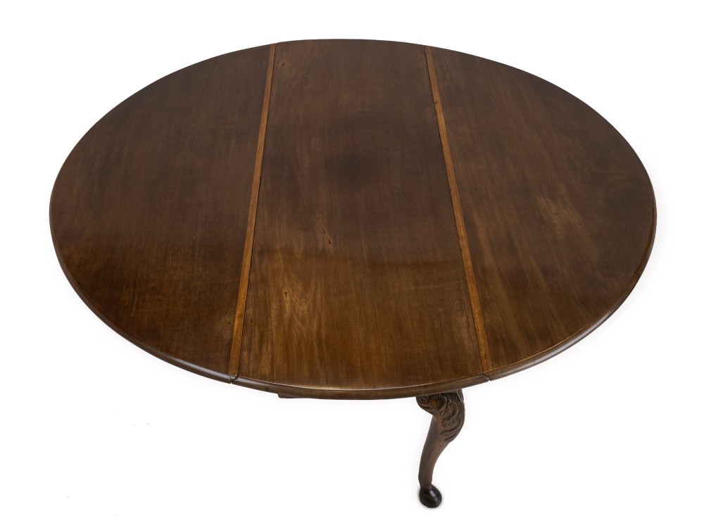 A George II Irish mahogany drop-leaf dining table with an oval top, end drawer, cabriole legs, and carved hoof feet. View VIII