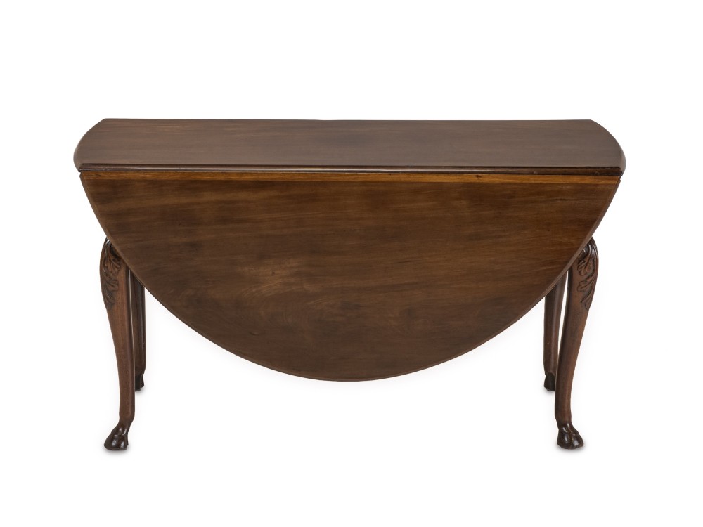 A George II Irish mahogany drop-leaf dining table with an oval top, end drawer, cabriole legs, and carved hoof feet. View IX
