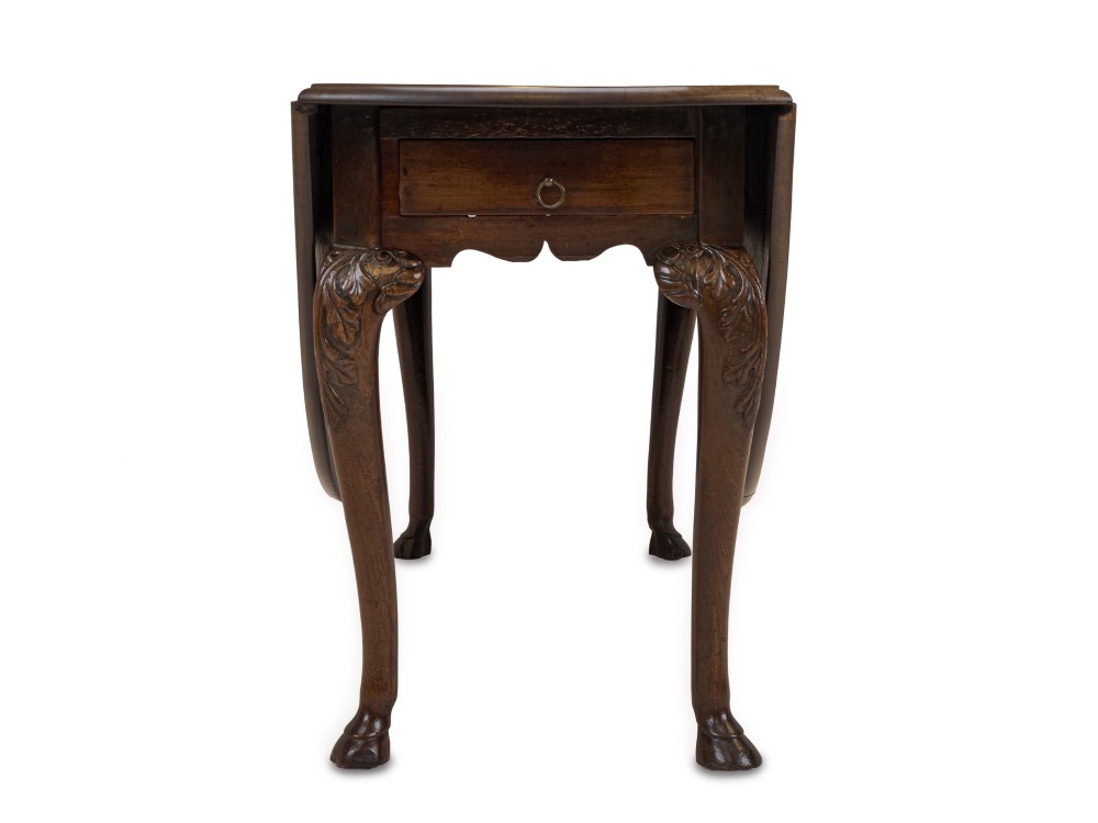A George II Irish mahogany drop-leaf dining table with an oval top, end drawer, cabriole legs, and carved hoof feet. View XII