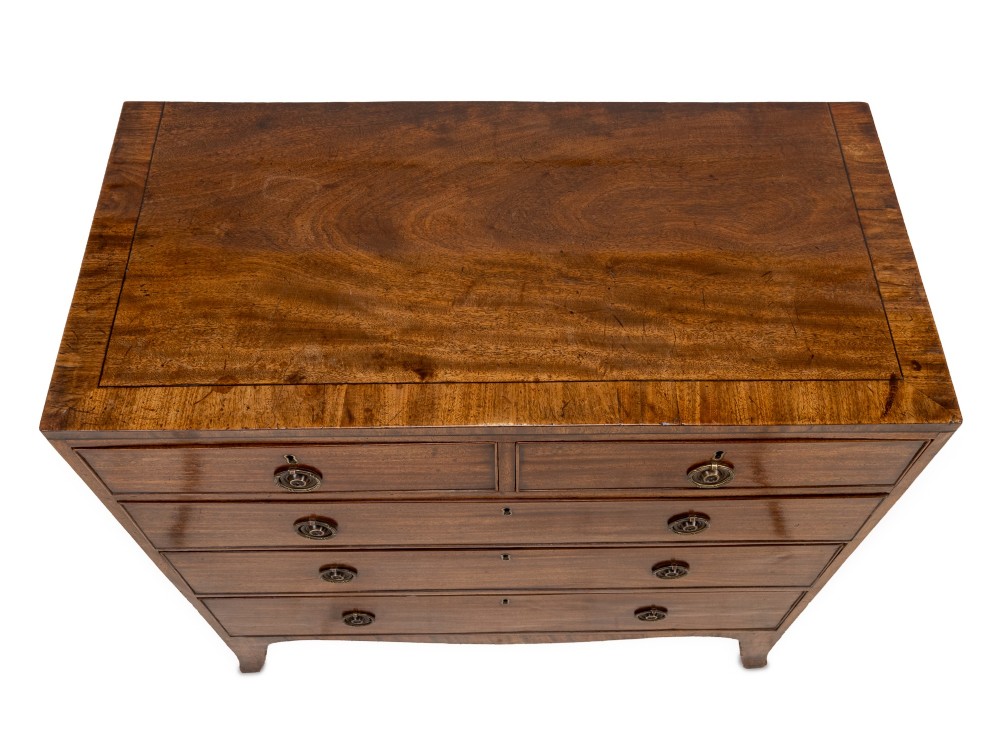 A late Georgian Regency mahogany chest of drawers featuring a caddy top, two short drawers over three long drawers, brass ring handles, and splayed bracket feet. View V