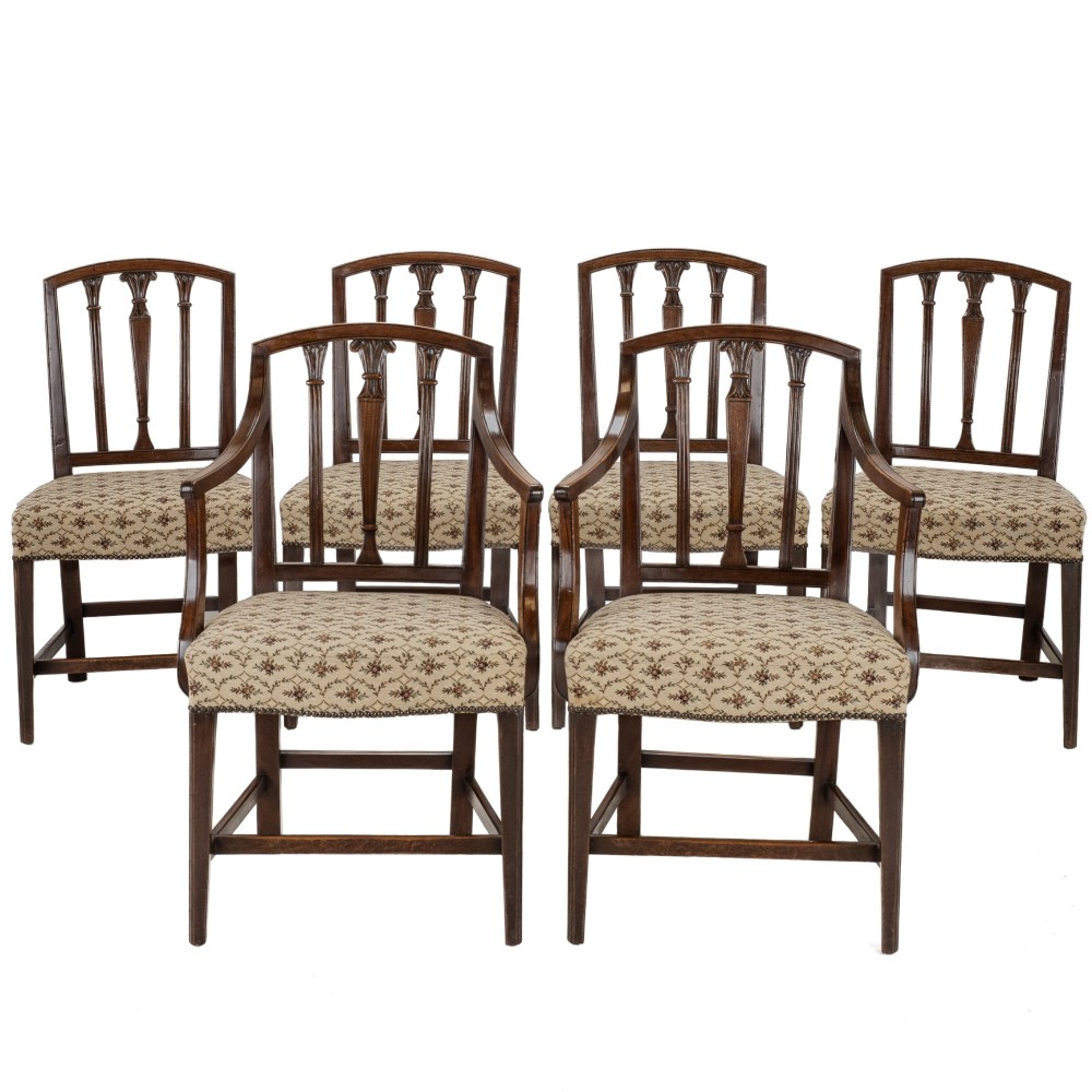 Set of six Georgian mahogany dining chairs in Sheraton style, including four side chairs and two open armchairs, with pattern upholstered seats.
