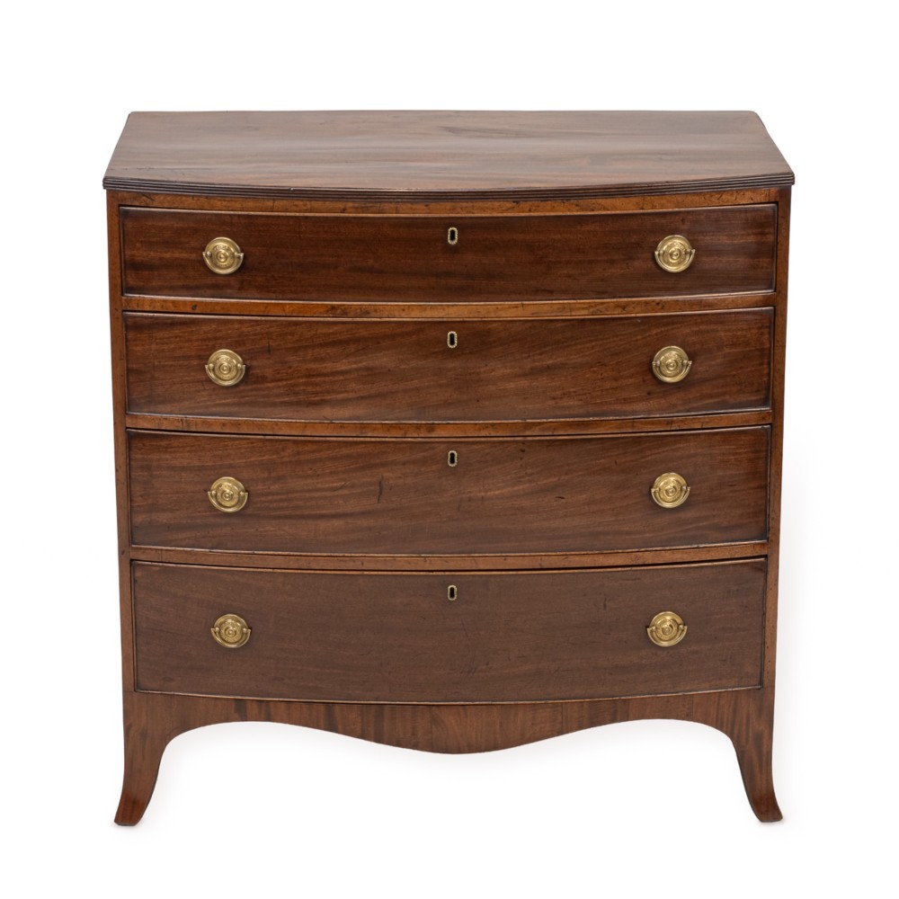 A Regency mahogany bow-front chest of drawers featuring four graduated drawers with circular brass ring handles and splayed bracket feet.