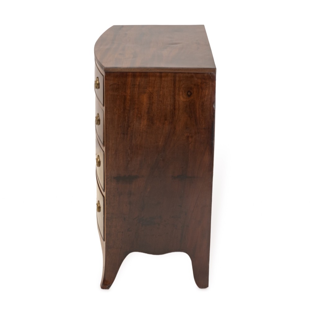 A Regency mahogany bow-front chest of drawers featuring four graduated drawers with circular brass ring handles and splayed bracket feet. View VII