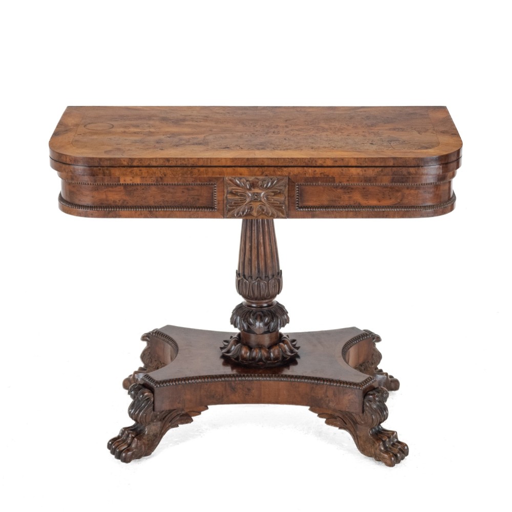 An antique William IV burr yew wood card table with a fold-over top, central carved pedestal column, and paw feet. View II
