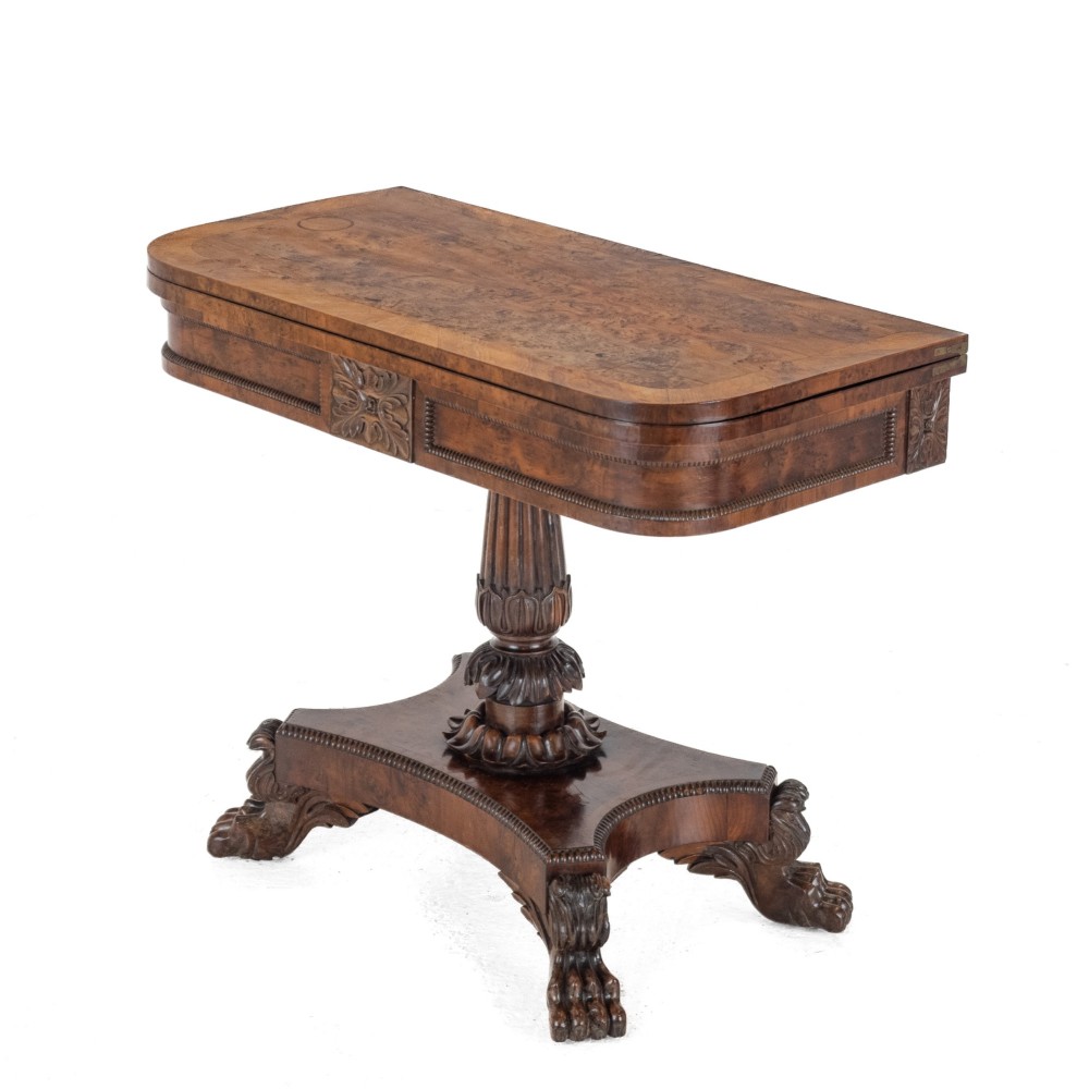 An antique William IV burr yew wood card table with a fold-over top, central carved pedestal column, and paw feet. View III