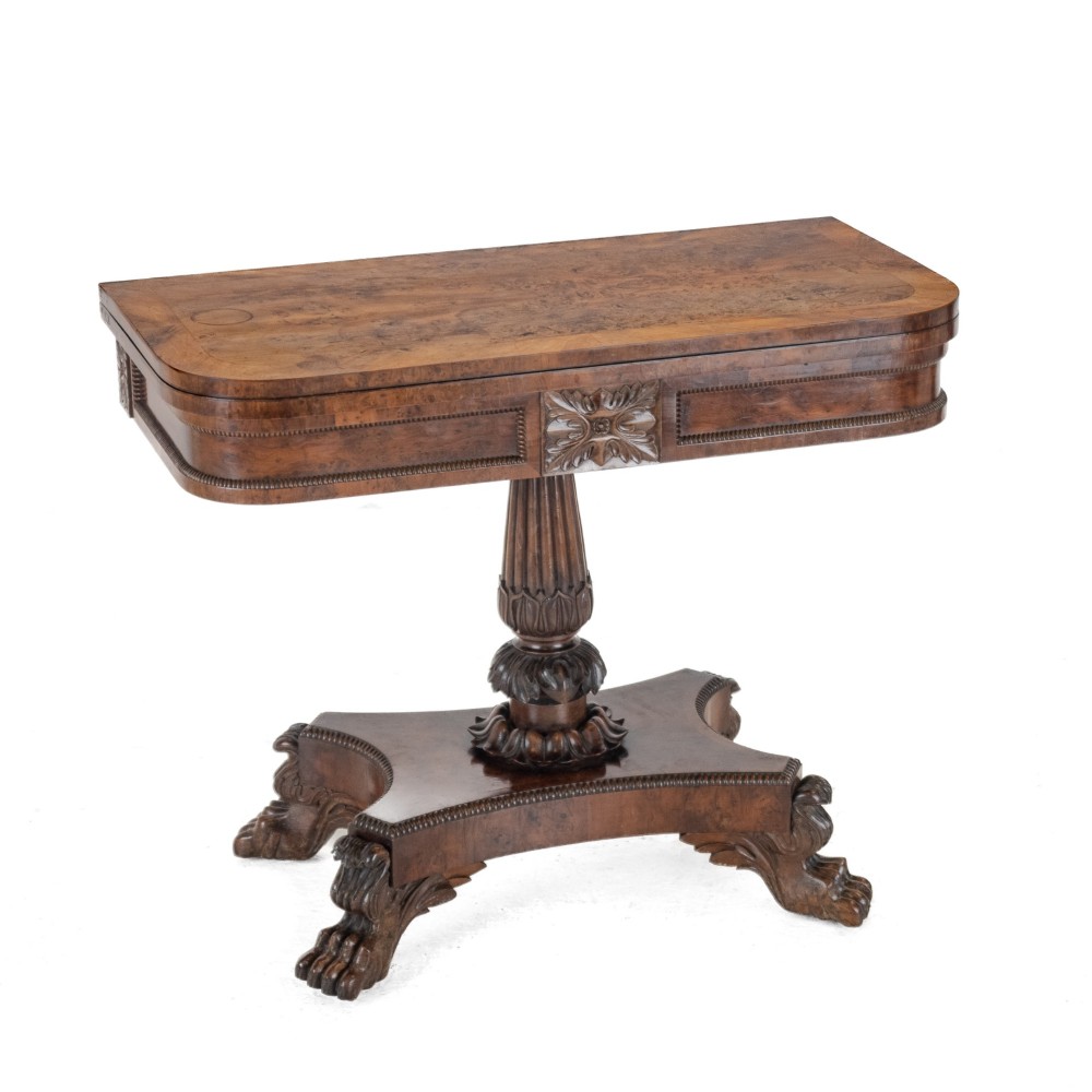 An antique William IV burr yew wood card table with a fold-over top, central carved pedestal column, and paw feet. View IV