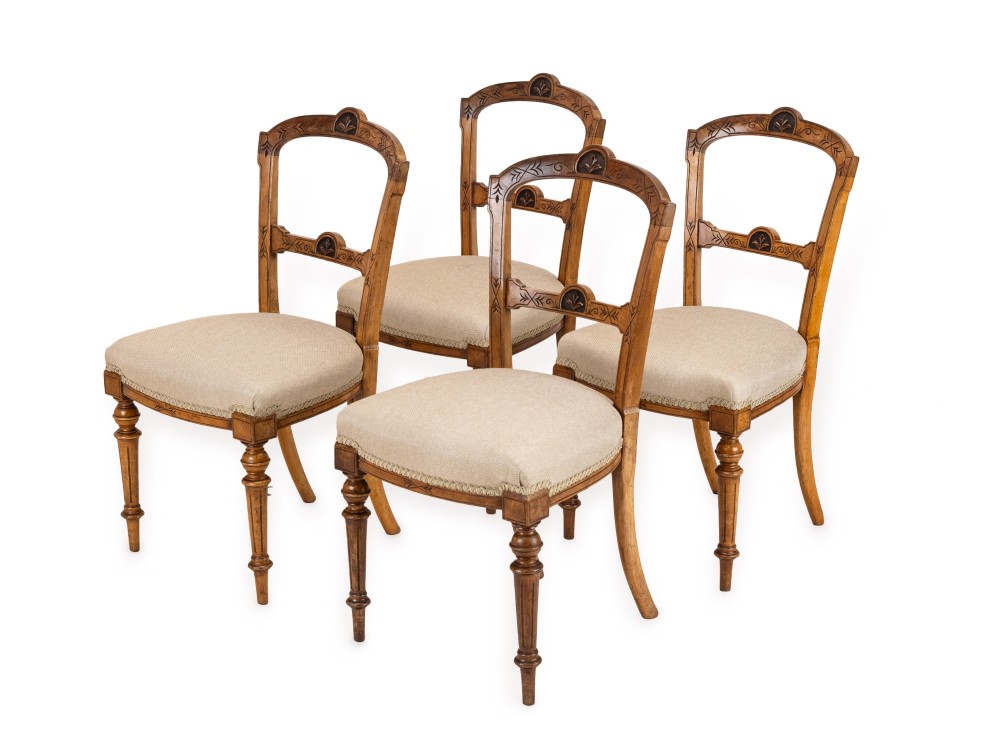 A set of four antique Regency satin birch dining chairs featuring carved crest rails, turned front legs, and neutral fabric upholstered seats. View II