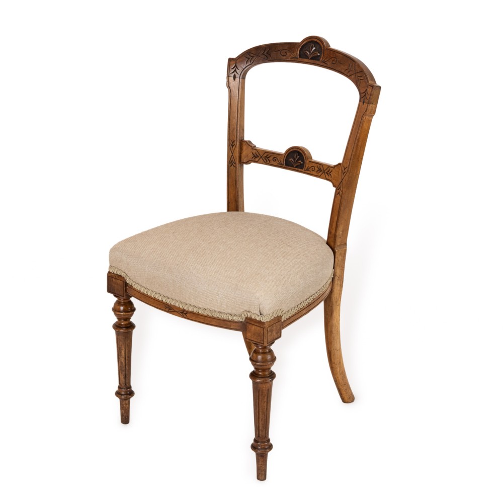 A set of four antique Regency satin birch dining chairs featuring carved crest rails, turned front legs, and neutral fabric upholstered seats. View V