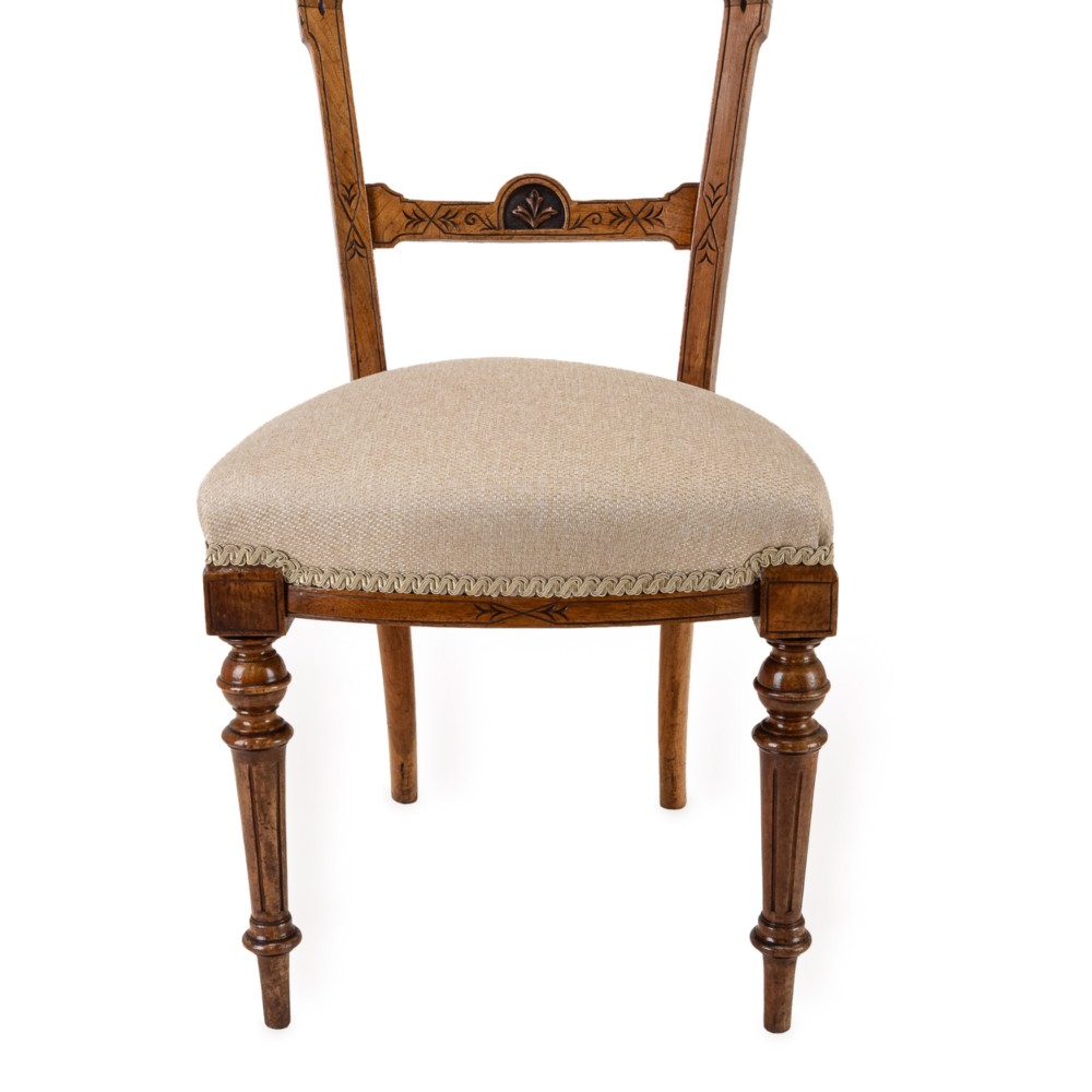 A set of four antique Regency satin birch dining chairs featuring carved crest rails, turned front legs, and neutral fabric upholstered seats. View VII