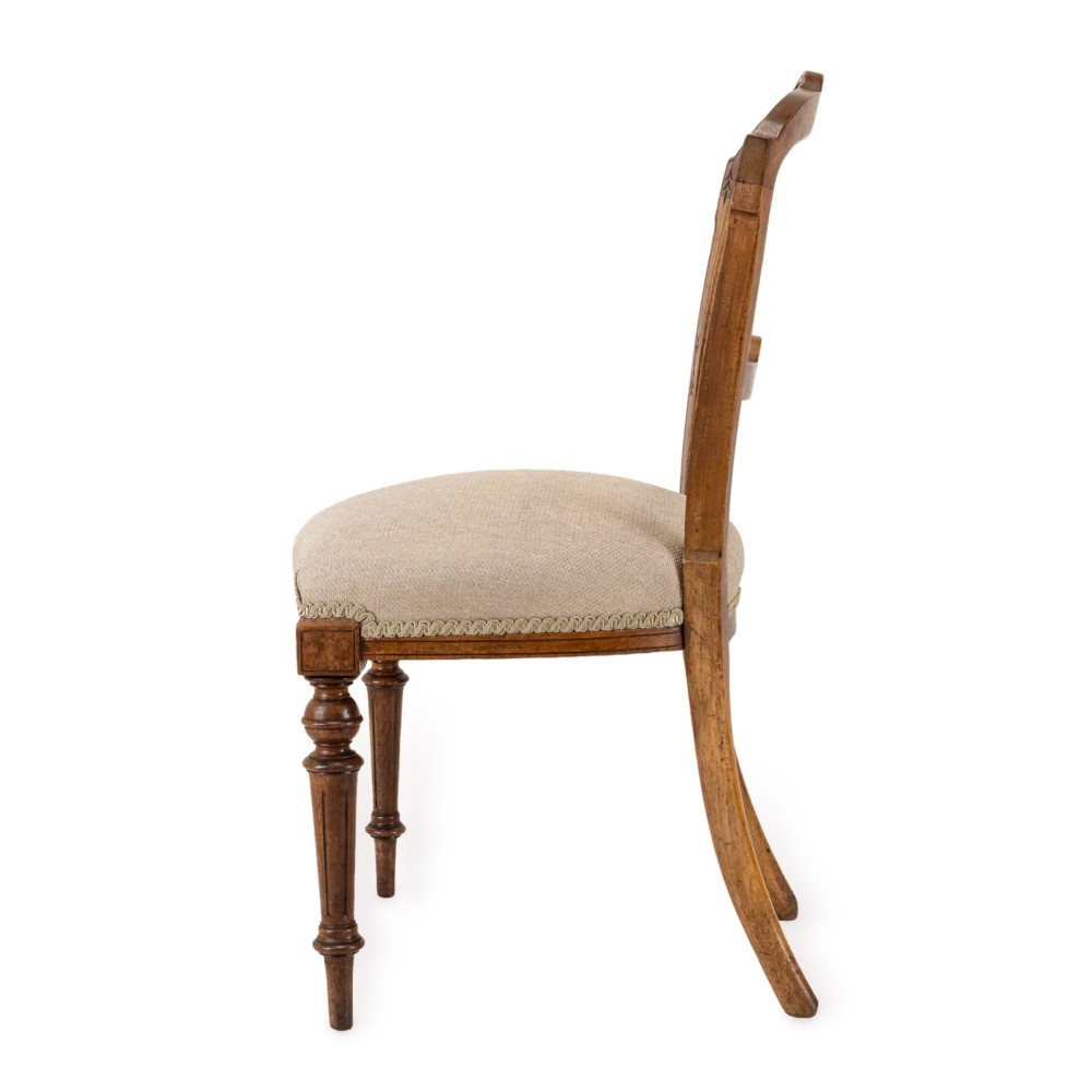 A set of four antique Regency satin birch dining chairs featuring carved crest rails, turned front legs, and neutral fabric upholstered seats. View VIII