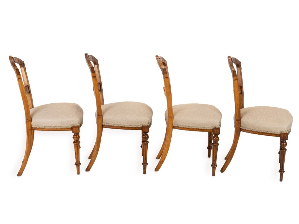 A set of four antique Regency satin birch dining chairs featuring carved crest rails, turned front legs, and neutral fabric upholstered seats. View IX