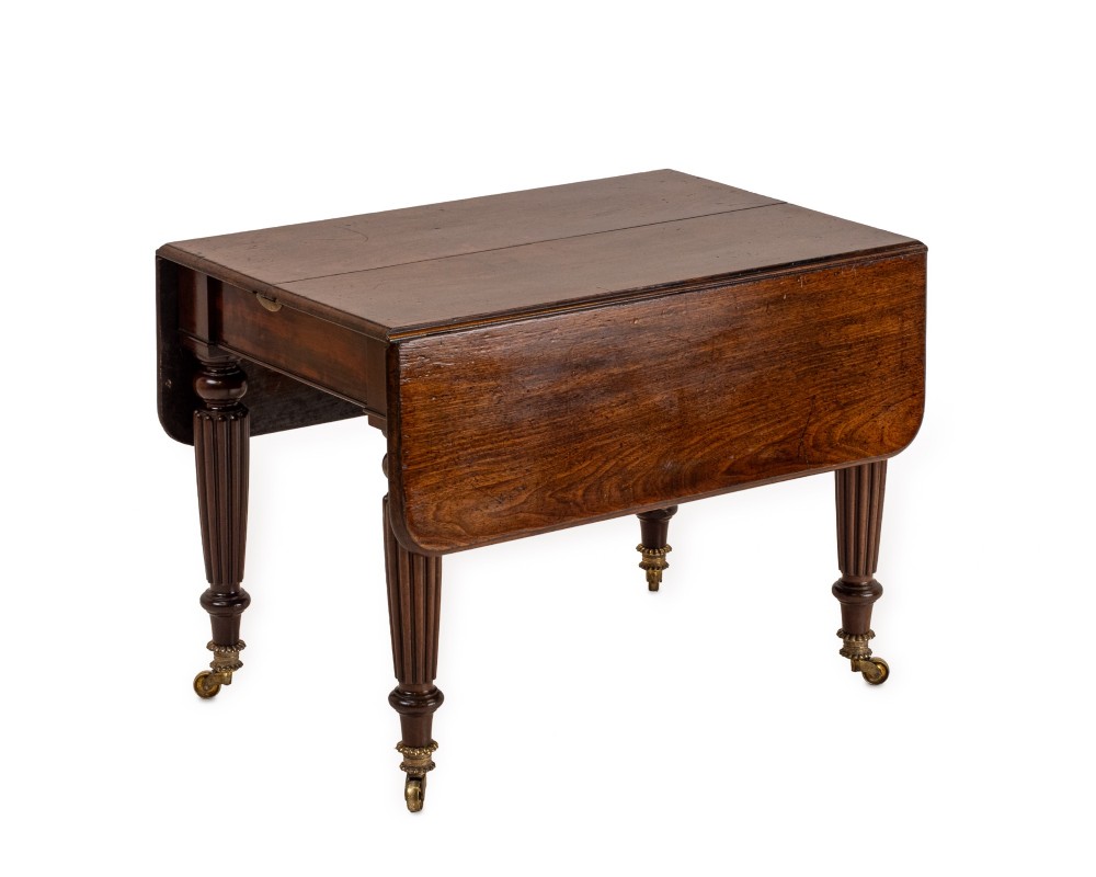 An extended Georgian mahogany dining table featuring a smooth polished surface, rectangular top with rounded corners, and reeded turned legs with brass castors. View II