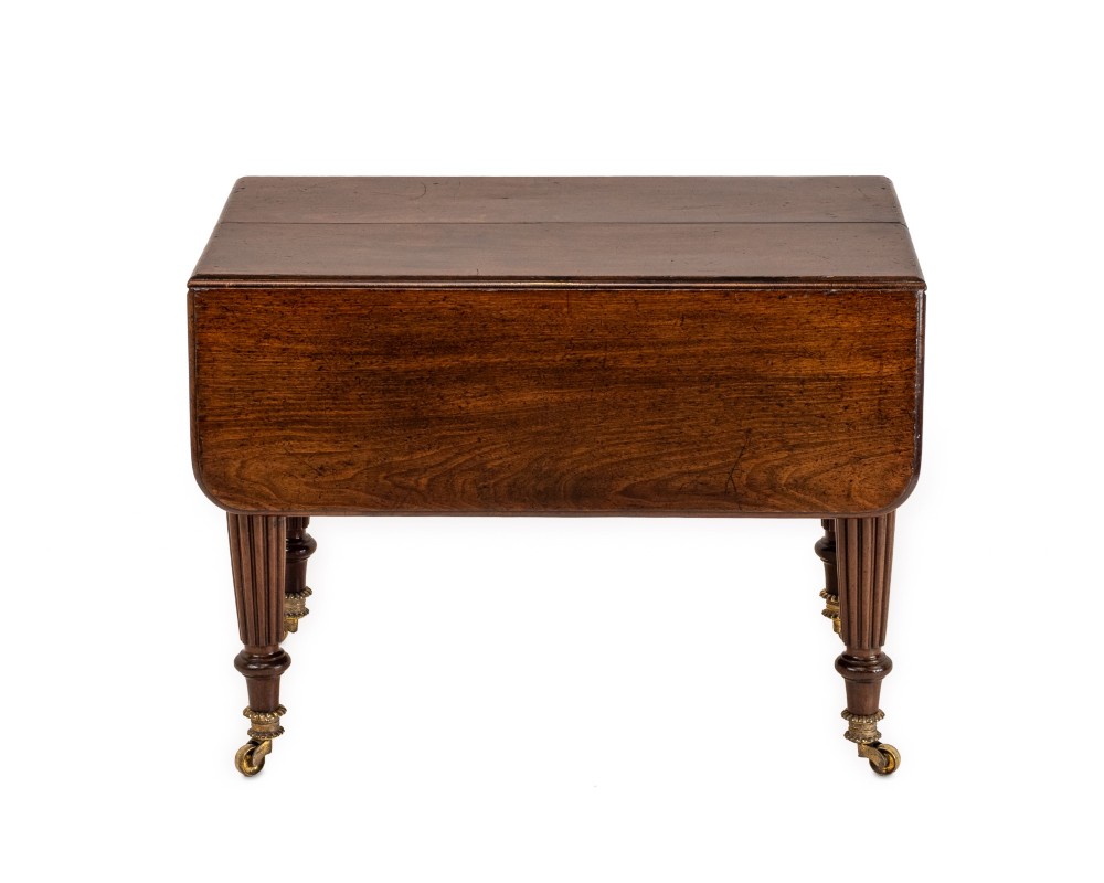 An extended Georgian mahogany dining table featuring a smooth polished surface, rectangular top with rounded corners, and reeded turned legs with brass castors. View X
