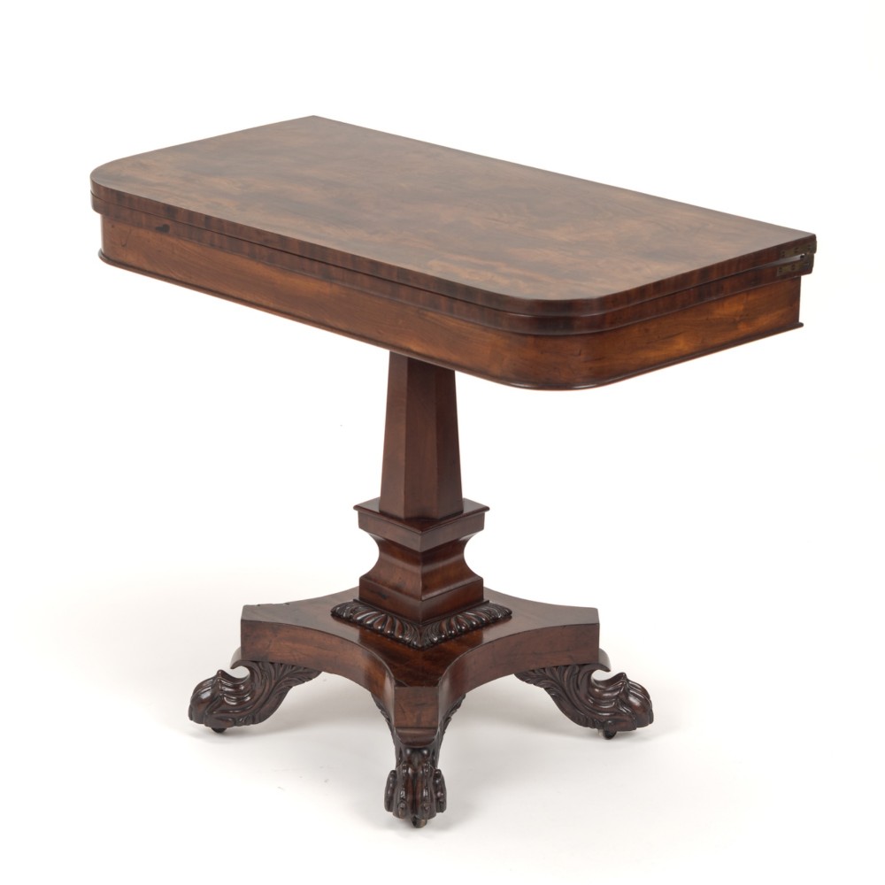 A late Regency mahogany fold-over tea table featuring a tapered central pedestal and carved paw feet on a concave quadform base. View III