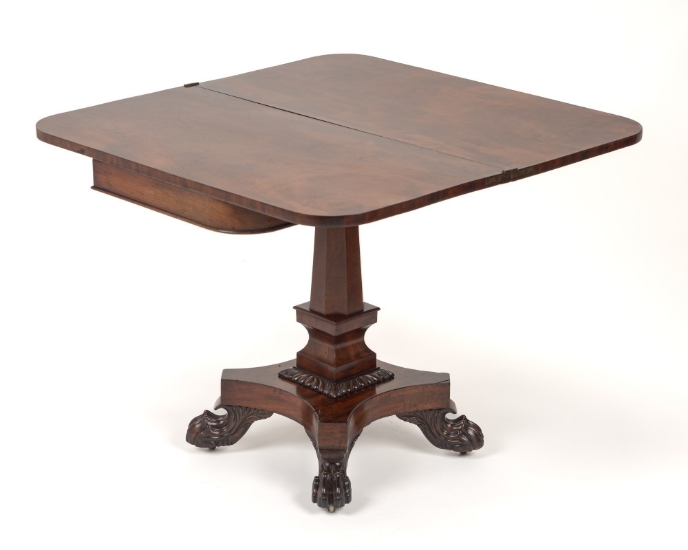 A late Regency mahogany fold-over tea table featuring a tapered central pedestal and carved paw feet on a concave quadform base. View XI