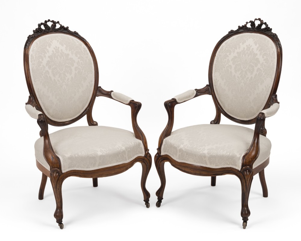 A pair of mid-19th century English rosewood Rococo Revival open armchairs with oval damask backs, carved top crests, padded arms, and cabriole legs on castors. View II