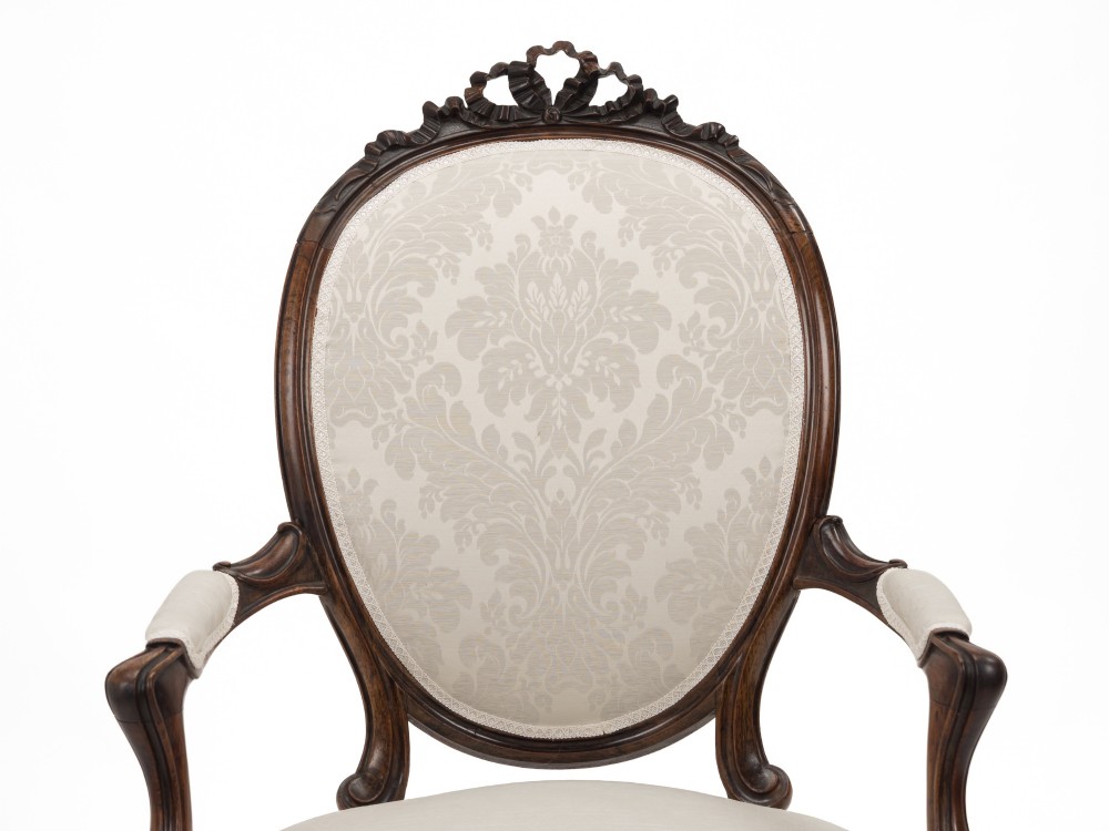 A pair of mid-19th century English rosewood Rococo Revival open armchairs with oval damask backs, carved top crests, padded arms, and cabriole legs on castors. View III