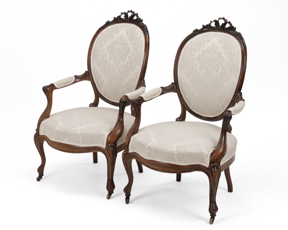 A pair of mid-19th century English rosewood Rococo Revival open armchairs with oval damask backs, carved top crests, padded arms, and cabriole legs on castors. View IV