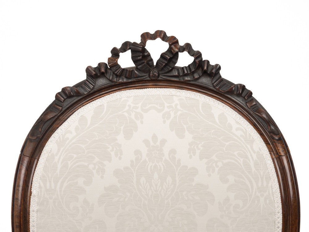 A pair of mid-19th century English rosewood Rococo Revival open armchairs with oval damask backs, carved top crests, padded arms, and cabriole legs on castors. View VII