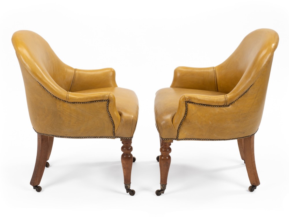 A pair of early 19th-century Regency library armchairs upholstered in warm tan leather with turned maple front legs on brass castors. View IV