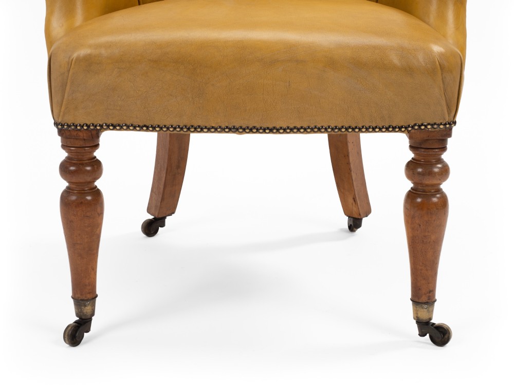 A pair of early 19th-century Regency library armchairs upholstered in warm tan leather with turned maple front legs on brass castors. View VIII